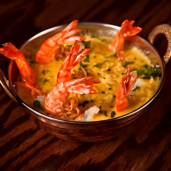 Swagat Fine Indian Cuisine's shrimp curry, with large shrimp in a rich yellow sauce, garnished with cilantro.