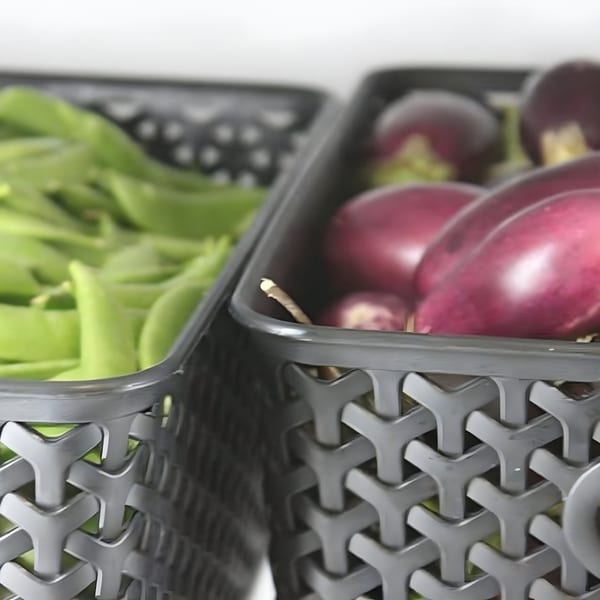 Baskets of fresh green beans and purple eggplants, ready for Indian cuisine preparation.